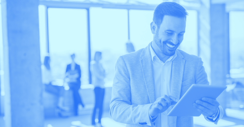 Man smiling while holding a tablet