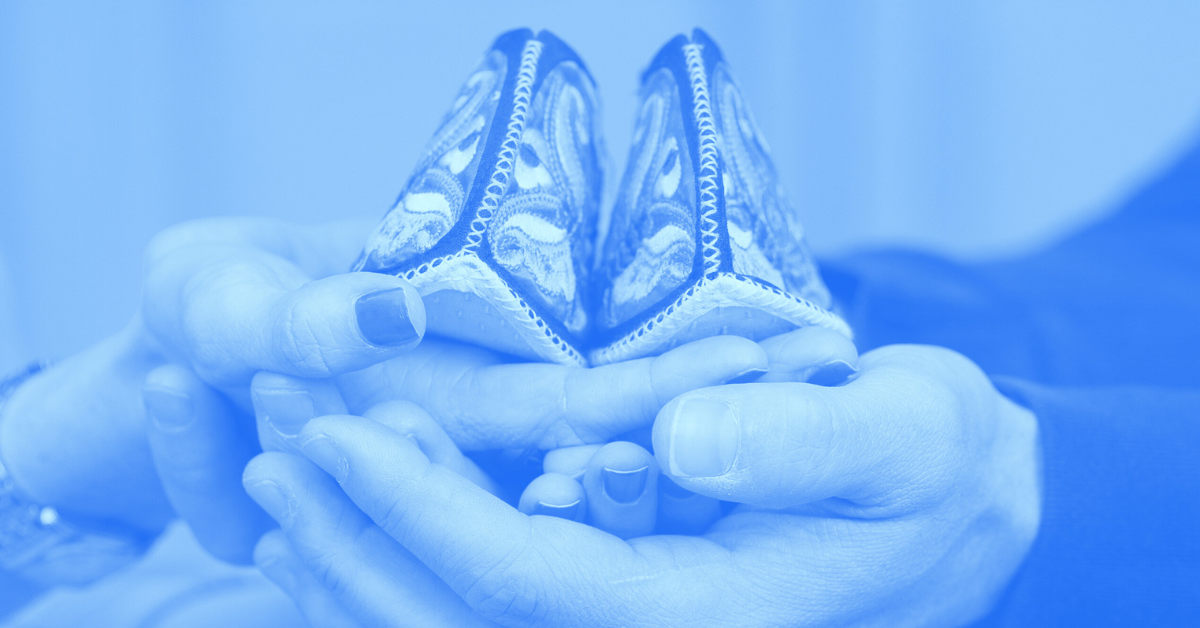 Couple holding a pair of baby shoes together